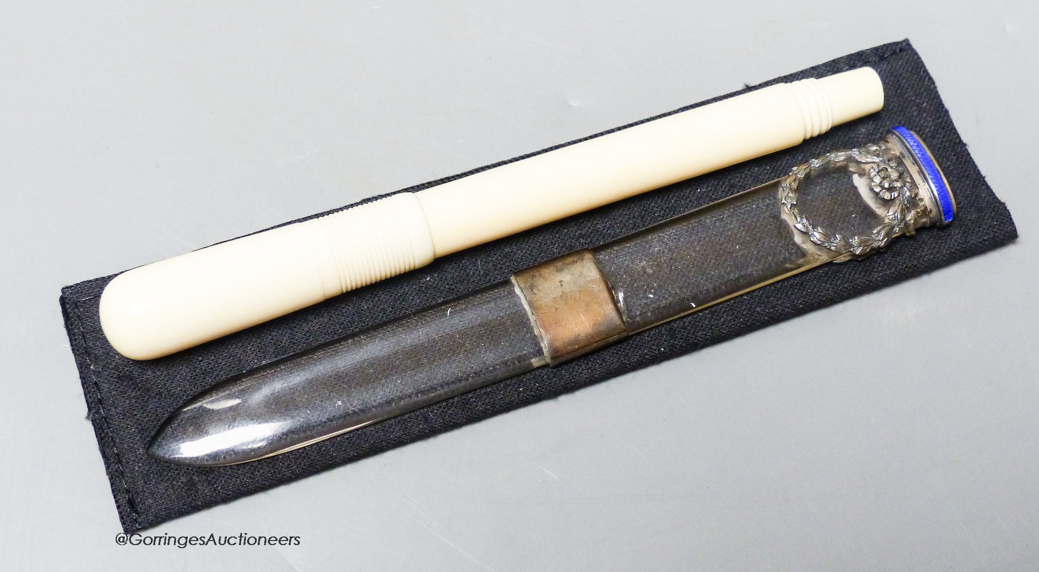 An early 20th century ivory eye dropper pen and an enamelled white metal mounted paperknife